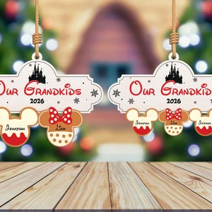 May include: Two wooden Christmas ornaments with the text "Our Grandkids 2026". Each ornament has a Mickey Mouse head and a Minnie Mouse head. The names Jonathan, Liam, and Jackson are written on the ornaments.
