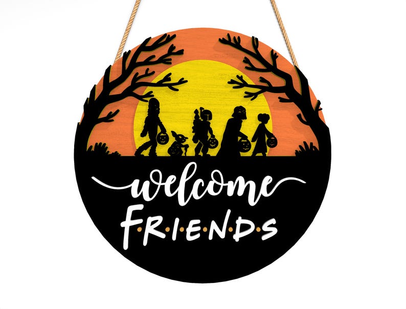 Pu&ograve; includere: Cartello rotondo in legno di Halloween con una silhouette nera di bambini che fanno dolcetto o scherzetto contro un tramonto arancione e giallo. Il cartello recita "welcome FRIENDS" in corsivo bianco e lettere maiuscole, con una corda di iuta per appenderlo.