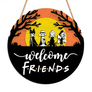 Pu&ograve; includere: Cartello di benvenuto rotondo in legno con cattivi dei cartoni animati sullo sfondo di un tramonto arancione e giallo. Il cartello recita "welcome FRIENDS" in scrittura bianca. Un elemento decorativo per Halloween o decorazioni a tema.