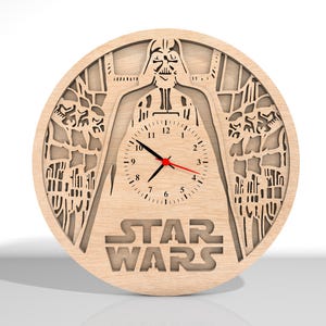 Puede incluir: Un reloj de pared de madera con una silueta de Darth Vader de Star Wars. La esfera del reloj es blanca con n&uacute;meros negros y una aguja de segundos roja. El reloj est&aacute; rodeado por un dise&ntilde;o detallado del universo de Star Wars.