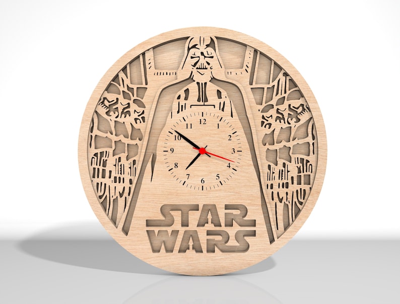Puede incluir: Un reloj de pared de madera con una silueta de Darth Vader de Star Wars. La esfera del reloj es blanca con n&uacute;meros negros y una aguja de segundos roja. El reloj est&aacute; rodeado por un dise&ntilde;o detallado del universo de Star Wars.