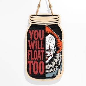 Puede incluir: Cartel de madera con forma de tarro con el texto "YOU WILL FLOAT TOO" en rojo. El lado derecho presenta un gr&aacute;fico de un payaso aterrador con pelo rojo y maquillaje blanco. El cartel cuelga de una cuerda de yute.