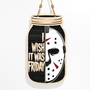 Puede incluir: Cartel de madera con forma de tarro, con un dise&ntilde;o en blanco y negro. El dise&ntilde;o incluye el texto "I WISH IT WAS FRIDAY" y una m&aacute;scara de hockey. El cartel est&aacute; suspendido por una cuerda natural.