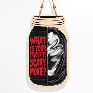 Puede incluir: Letrero de madera con forma de tarro, con la pregunta "WHAT IS YOUR FAVOURITE SCARY MOVIE?" en rojo. El lado izquierdo es negro, el lado derecho presenta una imagen fantasmal blanca. Se adjunta una cuerda de yute para colgarlo.
