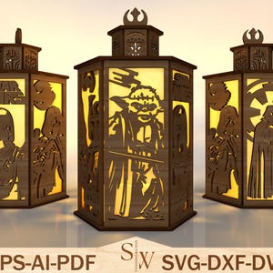 May include: Three wooden lanterns with Star Wars character cutouts. The lanterns feature Yoda, Darth Vader, and Boba Fett designs. The Star Wars logo is visible on one lantern. The lanterns are illuminated from within, creating a warm glow.