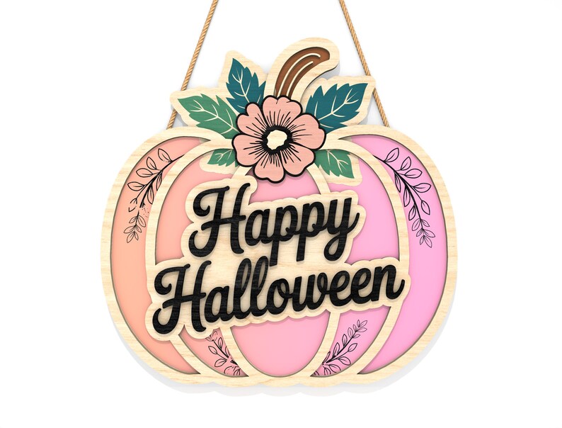 May include: A wooden pumpkin-shaped sign with the words "Happy Halloween" in black script. The sign features a pink and orange gradient, floral accents, and a decorative flower. It hangs from a natural rope.