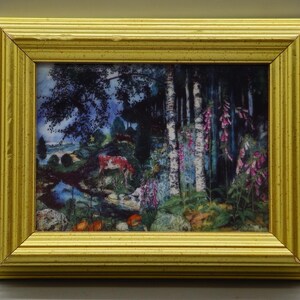 Puede incluir: Pintura de paisaje enmarcada con un marco de madera dorada. La obra representa una escena de bosque con abedules, un arroyo y ciervos. Dedaleras rosas y otro follaje añaden color a la escena.