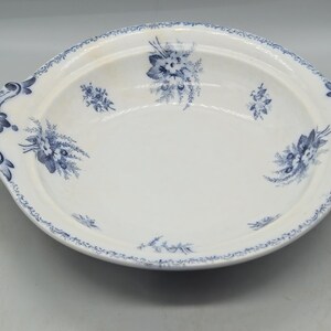 Op de afbeelding: Witte ovale serveerschaal met blauwe bloempatronen en decoratieve handvatten. De schaal heeft een delicaat blauw bloemmotief langs de rand en in het midden. Een klassiek stuk om eten te serveren of als decoratief item.