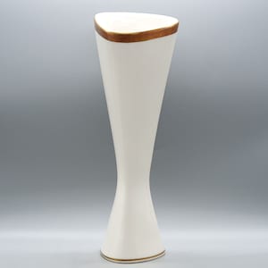 May include: A white ceramic vase with a gold rim. The vase is shaped like an hourglass and has a triangular base.