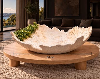 May include: A large, off-white, textured bowl with an irregular, organic rim, containing small green artificial plants. The bowl is positioned on a round wooden coffee table, with a measurement graphic indicating a diameter of 60 cm.