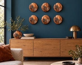 May include: Six circular wall art pieces with a textured, mottled copper and black finish arranged in two rows. These round decorative objects feature a metallic sheen and dark, weathered detailing, creating a cohesive visual display.