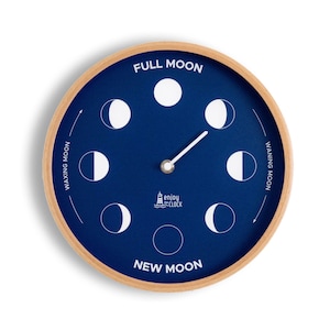 May include: A blue and white moon phase clock with a wooden frame. The clock face features the phases of the moon, with the words "Full Moon", "Waxing Moon", "Waning Moon", and "New Moon" printed around the edge. The clock also features the text "Enjoy the Clock".