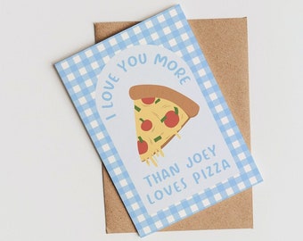 May include: A greeting card with a blue gingham border and the text "I love you more than Joey loves pizza." The card features a cartoon slice of pizza with cheese, tomatoes, and pepperoni. It rests on a brown envelope.