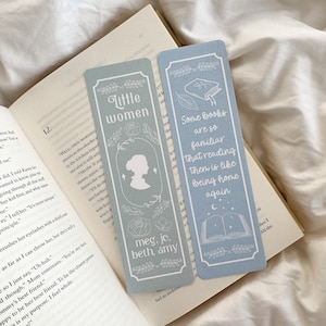Op de afbeelding: Twee rechthoekige bladwijzers met lichtblauwe achtergronden liggen op een open boek. Eén bladwijzer zegt "Little Women" met een silhouet en bloemmotieven. De andere zegt "Sommige boeken zijn zo vertrouwd dat lezen als thuiskomen is."