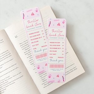 Op de afbeelding: Twee roze "Thriller Book Store" kassabon-bladwijzers met een boek. Elke bladwijzer bevat een lijst met thrillertitels en een "Bedankt"-bericht.