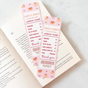 May include: Two pink bookmarks with a Luke's Diner customer receipt design. The receipts list pancakes, coffee, pie, and more. The bookmarks have illustrations of food and coffee cups. The text says "Thank you" and "Just hurry up and order!"