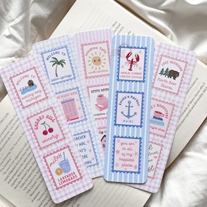 May include: A collection of decorative bookmarks with a travel theme. Each bookmark features a unique design, including illustrations of a palm tree, a sun, a lobster, and a cherry. The bookmarks have a postage stamp design with a gingham and striped background.