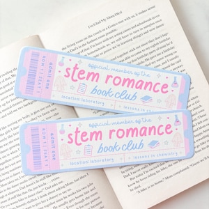 May include: Two rectangular bookmarks designed like admission tickets in pastel pink and blue. The text reads "official member of the stem romance book club" with icons of a lab coat, clipboard, books, and a flask. The text "admit one" is on the left.