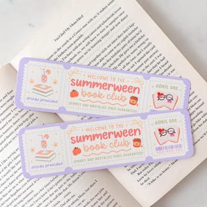May include: Two rectangular purple paper tickets with perforated edges featuring the text Welcome to the Summerween Book Club, admit one, and drinks provided. The design includes illustrations of a drink, a pumpkin, a jar, and an open book.
