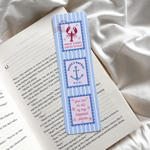 May include: A blue and white striped bookmark with three postage stamp designs. The top stamp features a red lobster and the text "Annual Summer Lobster Festival." The middle stamp says "Knott's Harbor Maine." The bottom stamp says "You are in all of my happiest places."