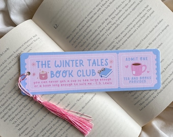 Könnte beinhalten: Hellblaues Lesezeichen mit dem Text "The Winter Tales Book Club" und einem Zitat von C.S. Lewis. Es hat rosa Akzente und eine rosa Quaste. Das Lesezeichen befindet sich in einem offenen Buch.