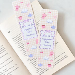 Op de afbeelding: Twee decoratieve bladwijzers met een lichtbeige ruitpatroon. Elke bladwijzer bevat illustraties van een koffiepot, een open boek, een theekopje, een theepot, kersen en een strik. De tekst "there is no enjoyment like reading" staat op elke bladwijzer.