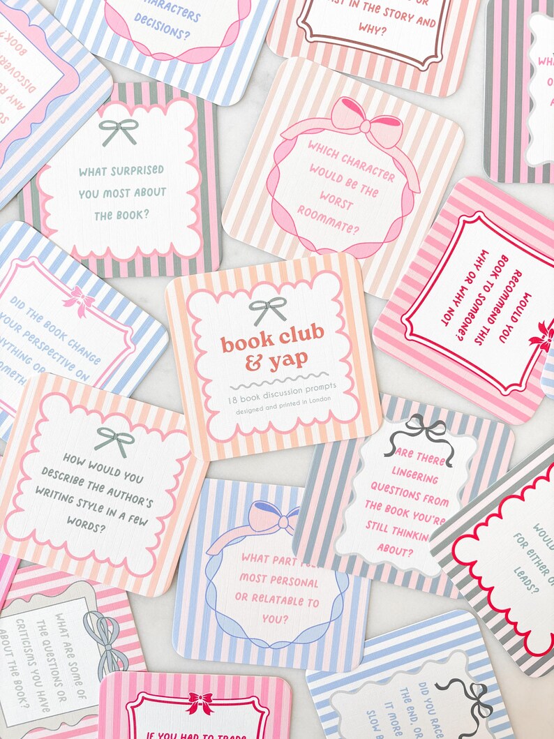 May include: A collection of pastel-colored book club discussion prompt cards. Each card features a unique question, decorative borders, and bow accents. The cards are designed with striped backgrounds in pink, blue, and gray.