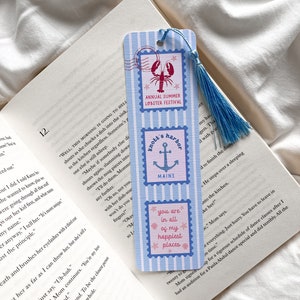 May include: A blue and white striped bookmark with three postage stamp designs. The top stamp reads "Annual Summer Lobster Festival" with a lobster illustration. The middle stamp says "Knott's Harbor, Maine" with an anchor. The bottom stamp says "you are in all of my happiest places."