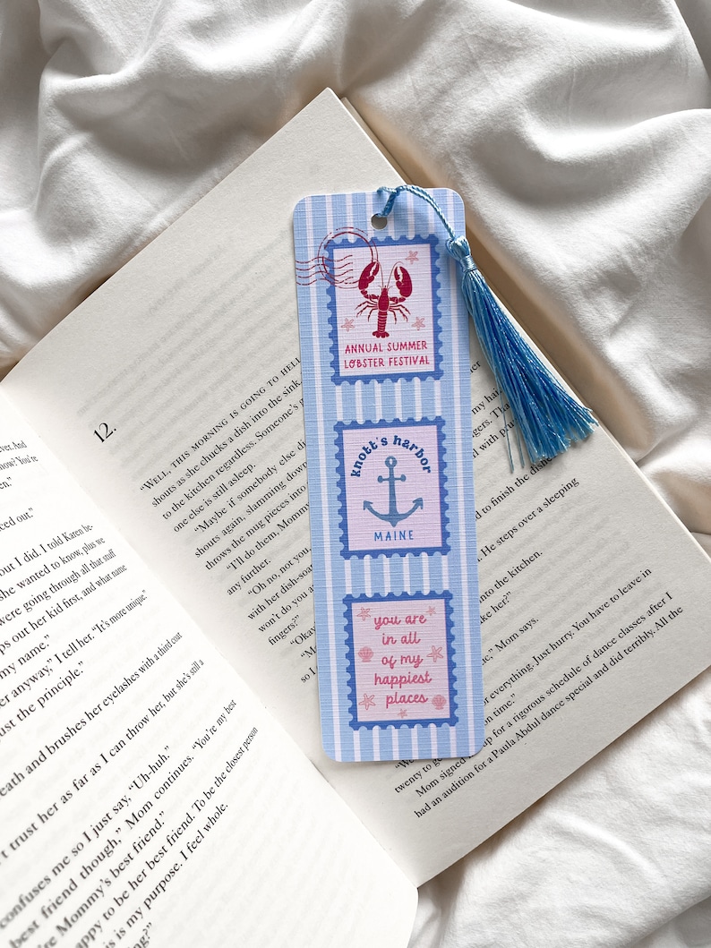 May include: A blue and white striped bookmark with three postage stamp designs. The top stamp reads "Annual Summer Lobster Festival" with a lobster illustration. The middle stamp says "Knott's Harbor, Maine" with an anchor. The bottom stamp says "you are in all of my happiest places."