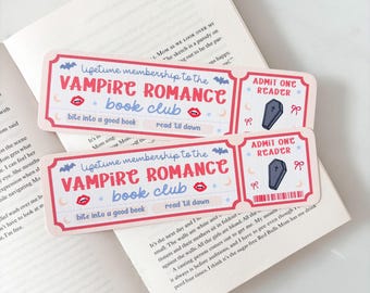 May include: Two decorative bookmarks with a ticket design, featuring the text "VAMPIRE ROMANCE book club." The bookmarks have a red and blue color scheme with bat and coffin illustrations. The text "bite into a good book" and "read til dawn" are also included.