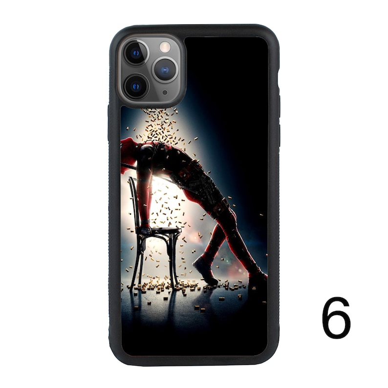 May include: A black iPhone case with a Deadpool character image. The character is lying on a chair with bullets falling around him. The case has a camera cutout and a black background.