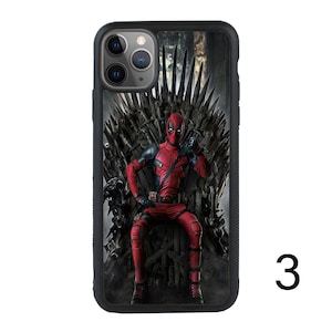 May include: A black iPhone case with a printed image of Deadpool sitting on the Iron Throne from Game of Thrones. The image is in a comic book style.