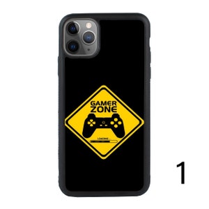 Puede incluir: Funda de tel&eacute;fono negra con una se&ntilde;al de advertencia amarilla que dice "Gamer Zone" y un mando de videojuegos negro dentro de la se&ntilde;al. La se&ntilde;al tiene una barra de progreso que dice "Loading".