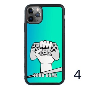 May include: A turquoise blue phone case with a black border. The case features a white illustration of a hand holding a video game controller. The text "YOUR NAME" is printed on the case.