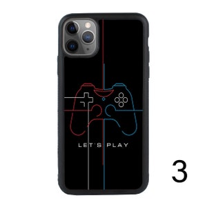Puede incluir: Carcasa de tel&eacute;fono negra con un contorno rojo y azul de un mando de videojuego. El texto "Let's Play" est&aacute; impreso debajo del mando.