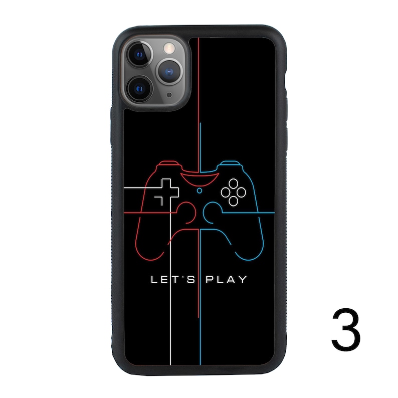 Puede incluir: Carcasa de tel&eacute;fono negra con un contorno rojo y azul de un mando de videojuego. El texto "Let's Play" est&aacute; impreso debajo del mando.
