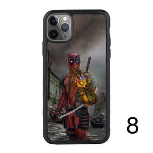 May include: A black phone case with a graphic of Deadpool wearing a red and black suit and holding the Infinity Gauntlet. The background is a blurry image of a city.