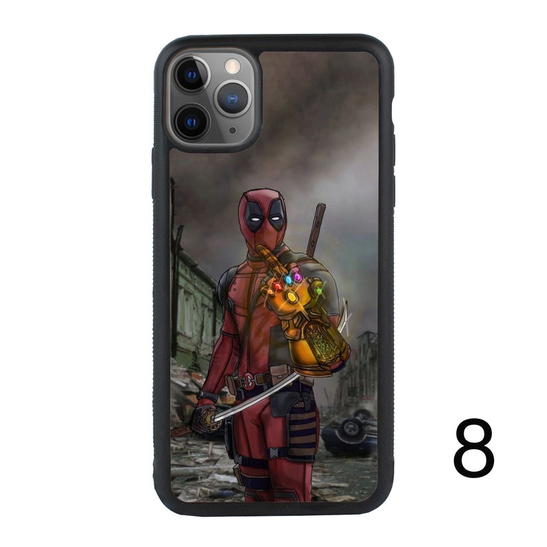 May include: A black phone case with a graphic of Deadpool wearing a red and black suit and holding the Infinity Gauntlet. The background is a blurry image of a city.