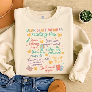 May include: Cream-colored sweatshirt with the text "DEAR STAFF MEMBER reading this..." in various colors. The design includes hearts, stars, and phrases like "You belong here" and "I'm Proud of you."