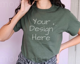 May include: A green t-shirt with the text "Your Design Here" in white. The shirt is being worn by a person with long dark hair.