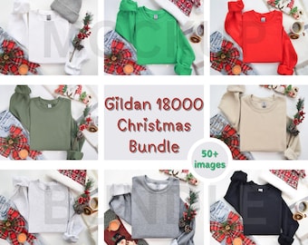 May include: A collection of Gildan 18000 sweatshirts in various colours, including white, green, red, beige, grey, and black. The sweatshirts are laid out on a white surface with a Christmas-themed background.