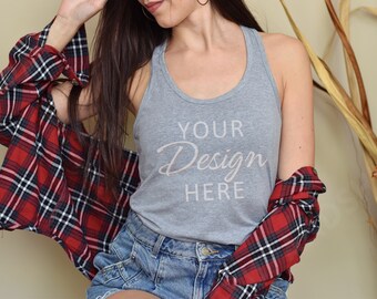 May include: A woman wearing a gray tank top with the text "YOUR Design HERE" printed on it. She is wearing a red and black plaid shirt over the tank top and blue denim shorts.