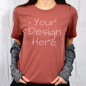 May include: A red heather t-shirt with the text "Your Design Here" printed on the front.