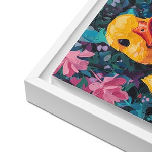 Puede incluir: Impresi&oacute;n art&iacute;stica en lienzo enmarcada que presenta una pintura impresionista vibrante de un pato amarillo con pico rojo, rodeado de flores rosas y exuberante follaje verde. La obra de arte est&aacute; enmarcada en un borde blanco limpio sobre un fondo oscuro.