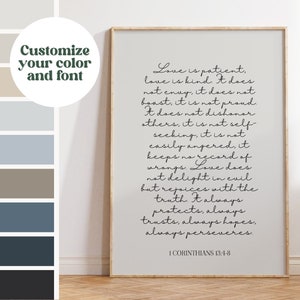 May include: A framed print with the text "Love is patient" from 1 Corinthians 13:4-8. The text is in a handwritten style, in black ink on a light gray background. The frame is a light wood color. The image also includes a color palette.