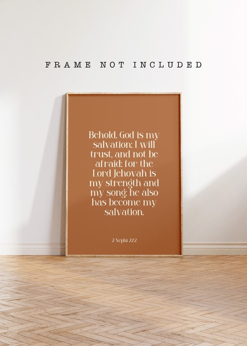 May include: A framed print with a warm terracotta background and white text. The text reads, "Behold, God is my salvation; I will trust, and not be afraid..." with a reference to 2 Nephi 22:2. The frame is not included.