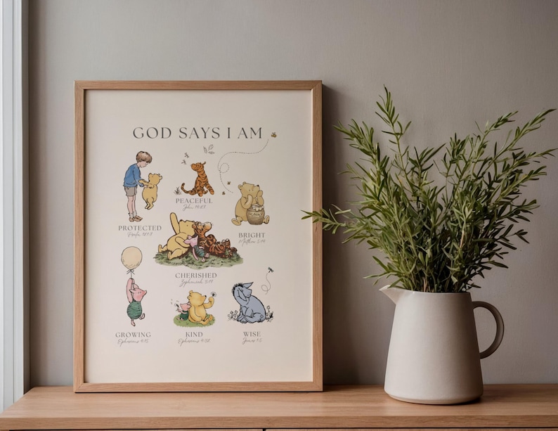 Puede incluir: Un estampado enmarcado con personajes de Winnie the Pooh y el texto "GOD SAYS I AM". Las ilustraciones incluyen a Pooh, Piglet, Tigger y Eeyore, con palabras como "Protegido", "Atesorado" y "Sabio". El marco es marr&oacute;n claro.