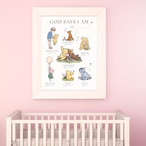 Puede incluir: Un cuadro enmarcado con el texto "GOD SAYS I AM" e ilustraciones de los personajes de Winnie the Pooh. El cuadro est&aacute; en un marco blanco y cuelga de una pared rosa sobre una cuna blanca. Las ilustraciones incluyen a Pooh, Piglet y Tigger.