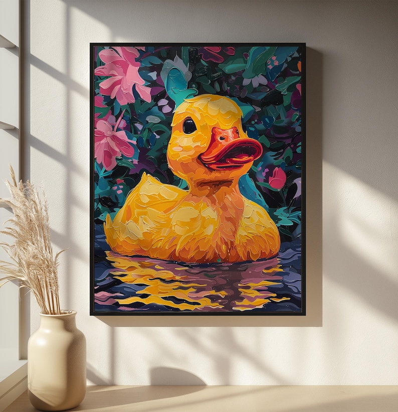 Puede incluir: Pintura enmarcada de un patito de goma amarillo con pico rojo y ojos negros en el agua. El fondo presenta flores rosas y hojas verdes. La obra de arte se presenta en un marco negro.