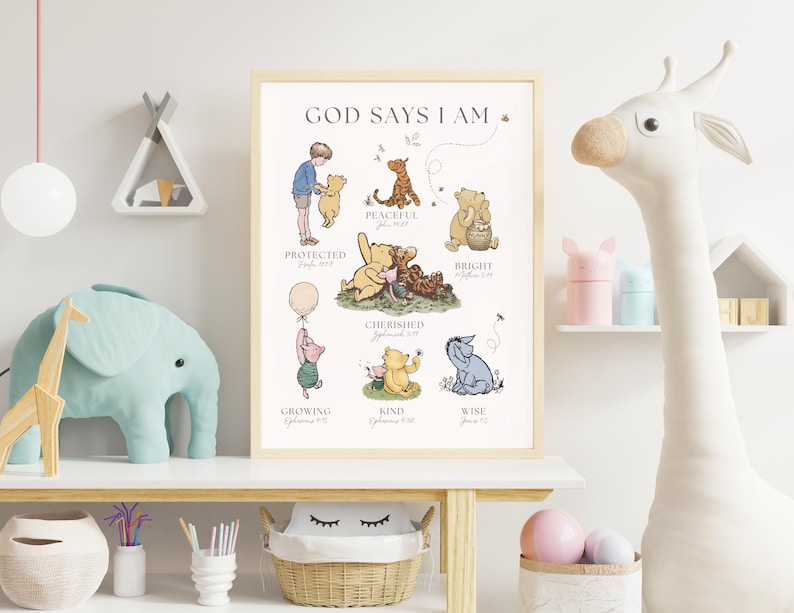Puede incluir: Un estampado enmarcado con personajes de Winnie the Pooh y el texto "GOD SAYS I AM". Las ilustraciones muestran a Pooh y sus amigos con palabras como "Protegido", "Pac&iacute;fico" y "Atesorado". La obra de arte est&aacute; en un marco de madera clara.